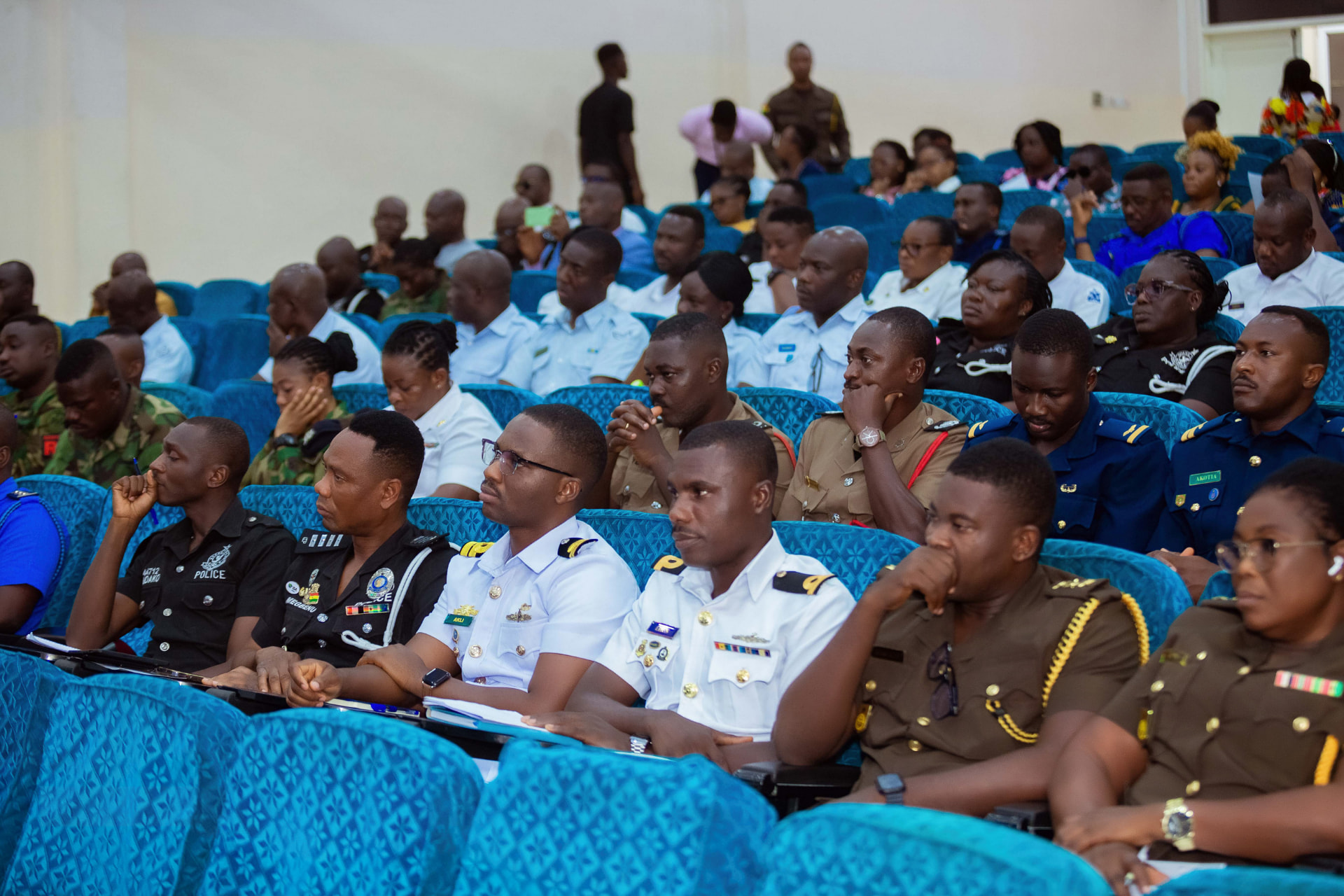 Security service officers seated in the auditorium, in police, naval, army and fire service dress