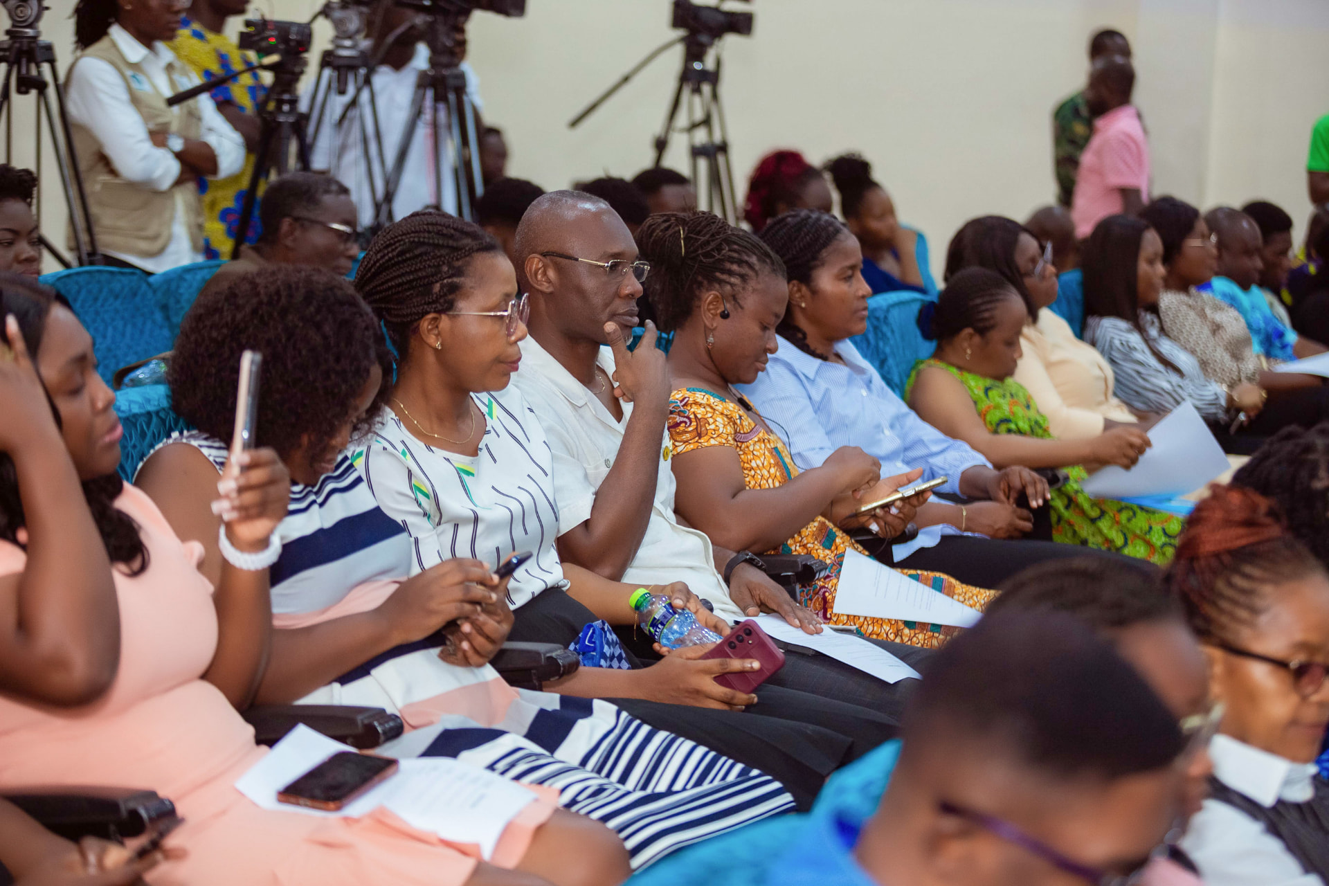 Journalists and delegates reviewing documents ahead of a session