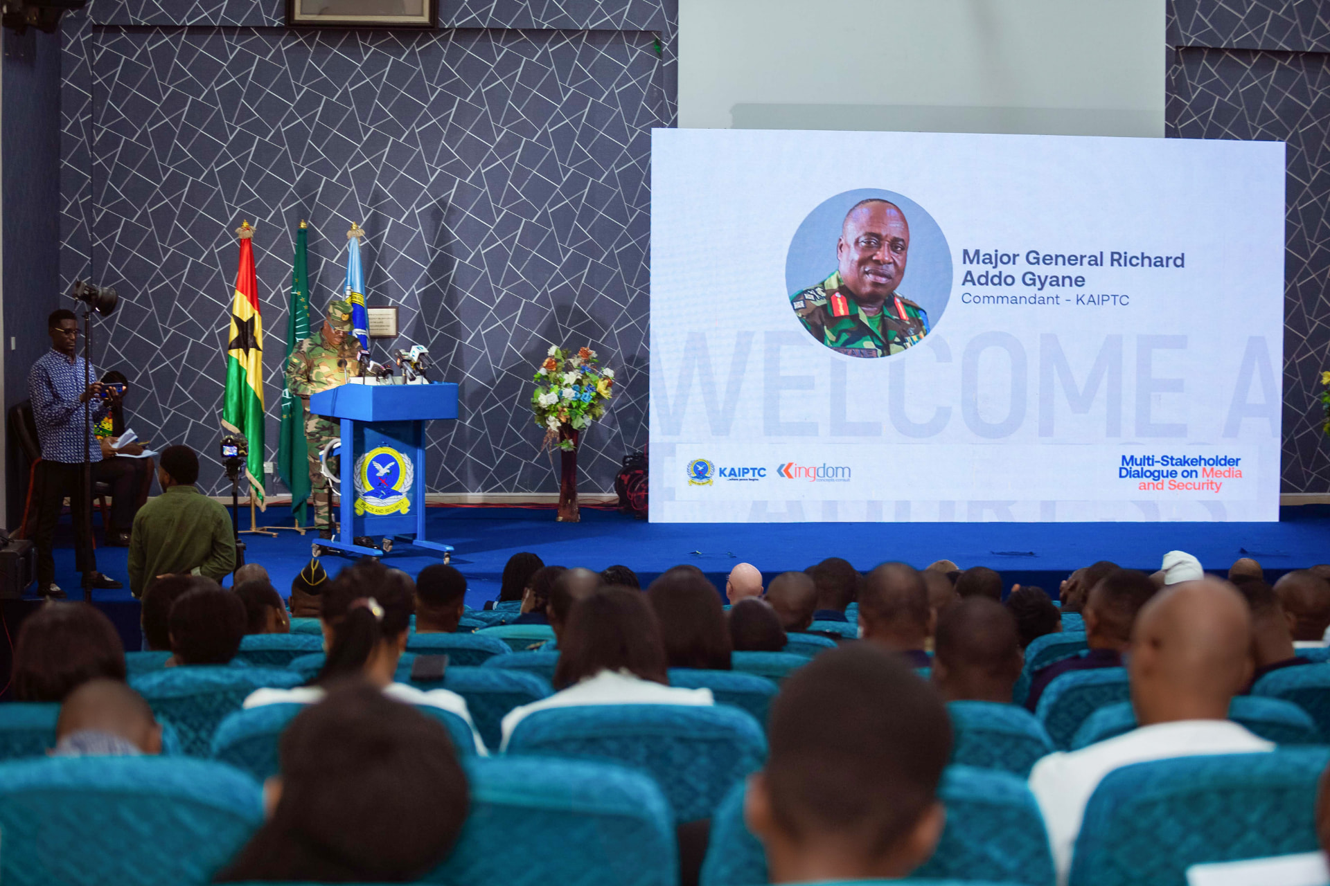 The stage at KAIPTC during the 2024 Dialogue, with the welcome screen and national flags